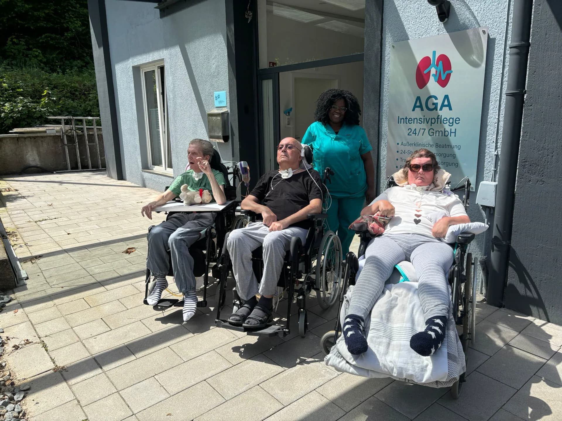 Bewohnerinnen und Bewohner mit Pflegefachkraft vor der AGA Intensivpflege-Wohngemeinschaft in Remscheid